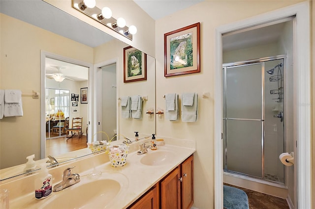 full bath with double vanity, a stall shower, and a sink