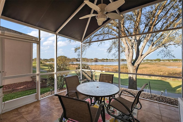 sunroom featuring ceiling fan and a water view