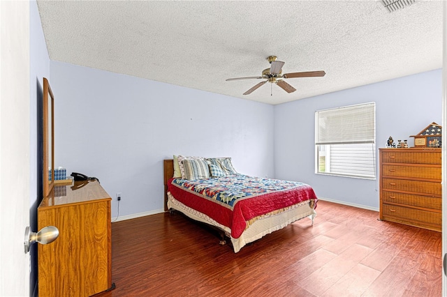 bedroom with hardwood / wood-style flooring, a textured ceiling, and ceiling fan