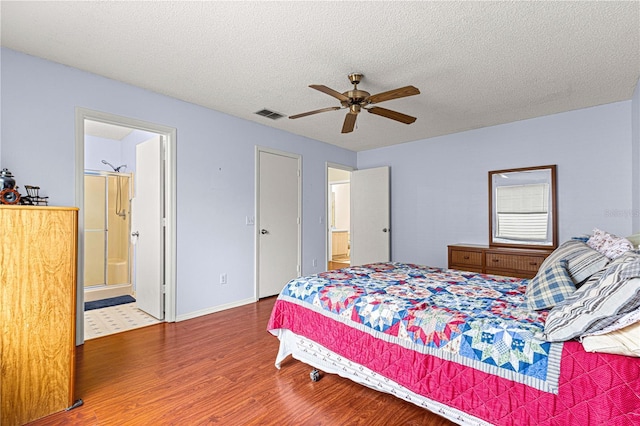 bedroom featuring hardwood / wood-style flooring, a textured ceiling, ceiling fan, and connected bathroom