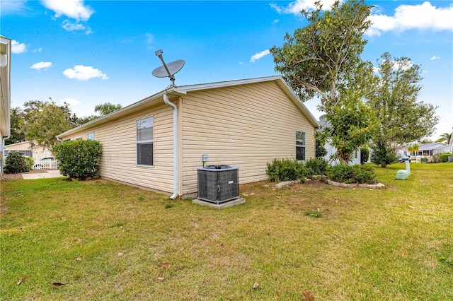 view of home's exterior with a lawn and central AC