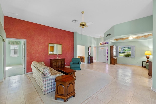 living room featuring ceiling fan, light tile patterned floors, and high vaulted ceiling