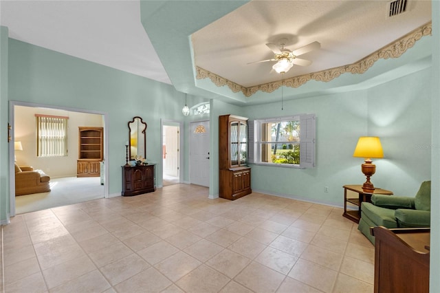 interior space featuring ceiling fan and a raised ceiling