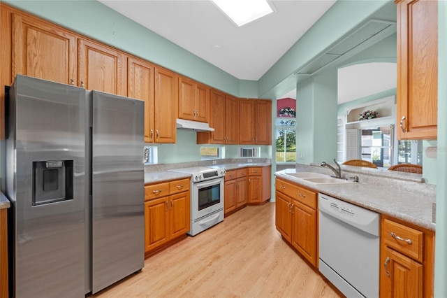 kitchen with sink, appliances with stainless steel finishes, and light hardwood / wood-style flooring