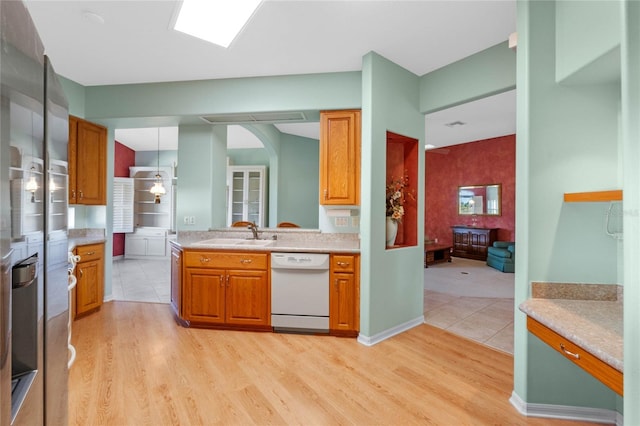 kitchen with wall oven, white dishwasher, pendant lighting, light hardwood / wood-style flooring, and sink