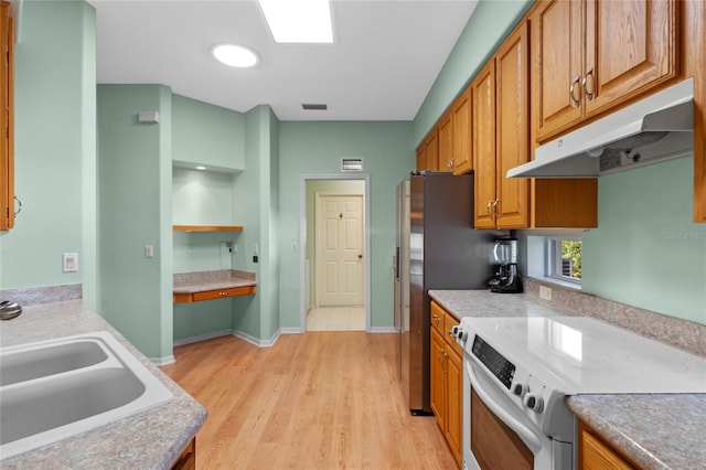 kitchen featuring electric range oven, light hardwood / wood-style flooring, and sink