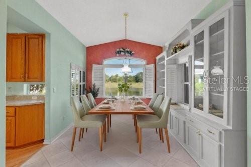 tiled dining room with vaulted ceiling