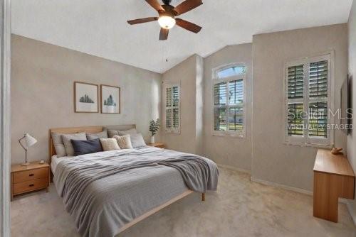 carpeted bedroom featuring ceiling fan and lofted ceiling