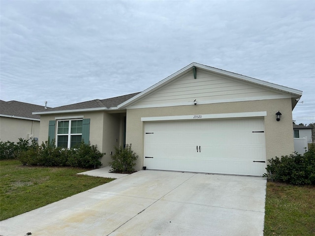 single story home with a front yard and a garage