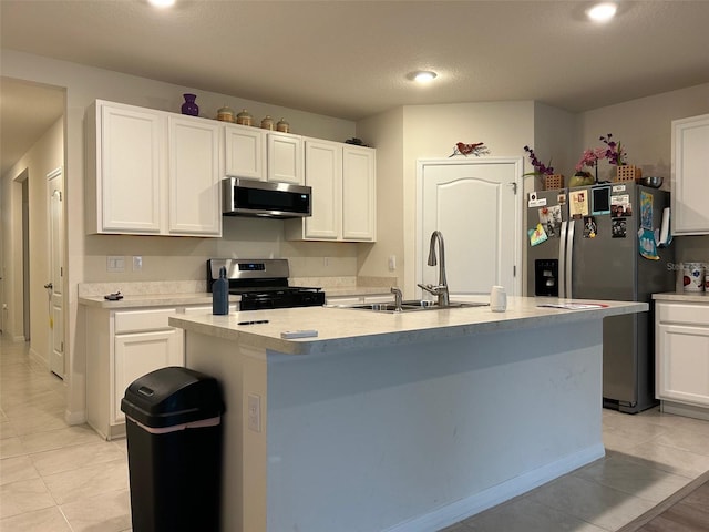 kitchen featuring a kitchen island with sink, sink, appliances with stainless steel finishes, light tile patterned flooring, and white cabinetry