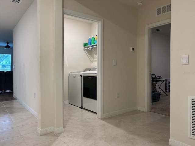 clothes washing area with washer and clothes dryer and light tile patterned floors