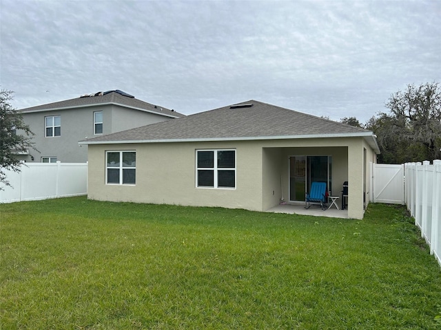 rear view of house with a yard and a patio