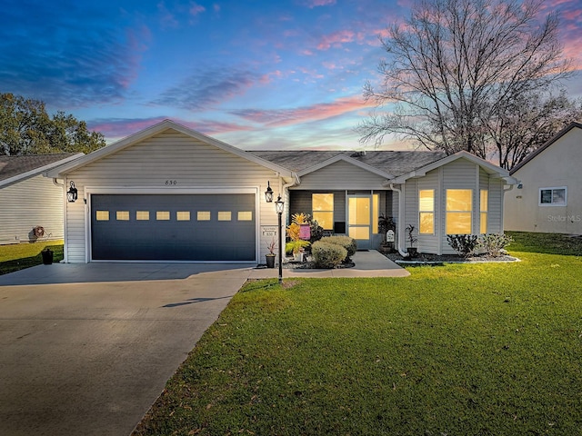 ranch-style house featuring a garage and a yard