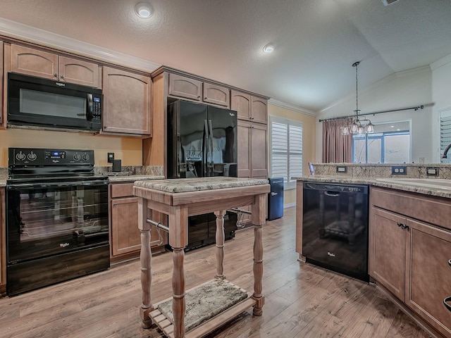 kitchen with lofted ceiling, sink, decorative light fixtures, light hardwood / wood-style floors, and black appliances