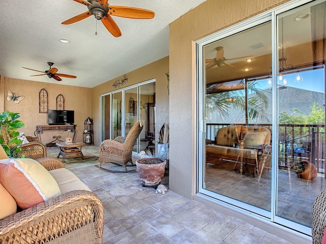 sunroom / solarium featuring ceiling fan