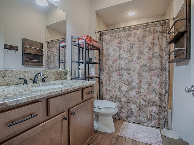 bathroom with wood-type flooring, vanity, and toilet