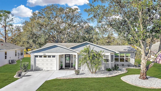 view of front of home featuring a front yard, a garage, and central AC