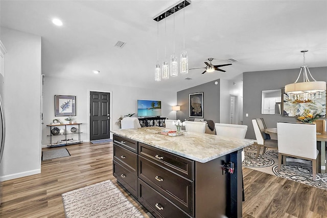 kitchen with decorative light fixtures, a kitchen island, ceiling fan, and dark hardwood / wood-style floors