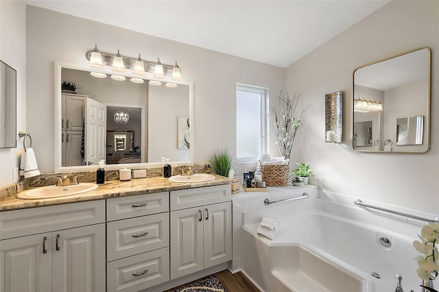 bathroom featuring wood-type flooring, vanity, and a bathtub