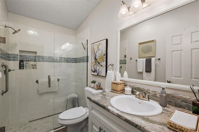 bathroom with toilet, a textured ceiling, walk in shower, and vanity