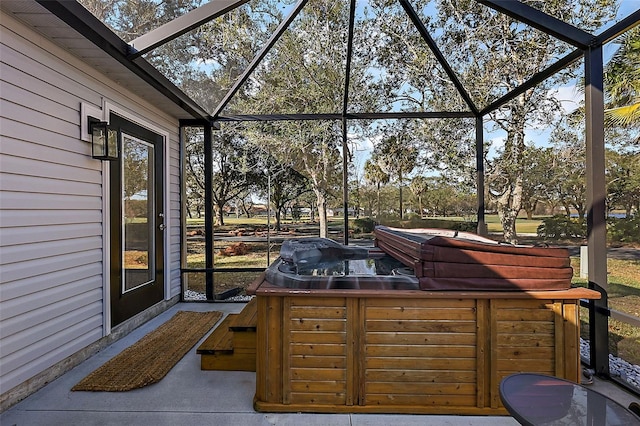 view of patio / terrace featuring a hot tub, glass enclosure, and grilling area