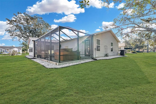 rear view of house featuring cooling unit, a yard, and glass enclosure