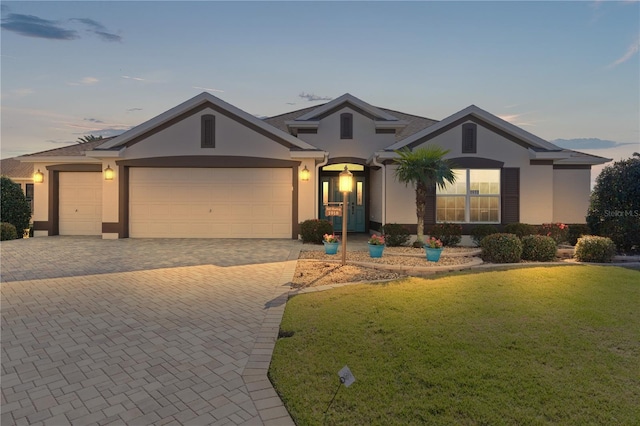 view of front of home with a garage and a lawn