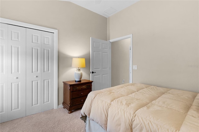 carpeted bedroom with a closet and lofted ceiling