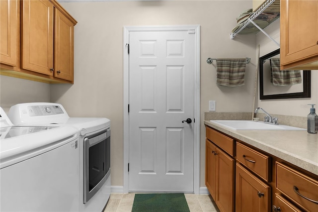 washroom with sink, light tile patterned floors, separate washer and dryer, and cabinets