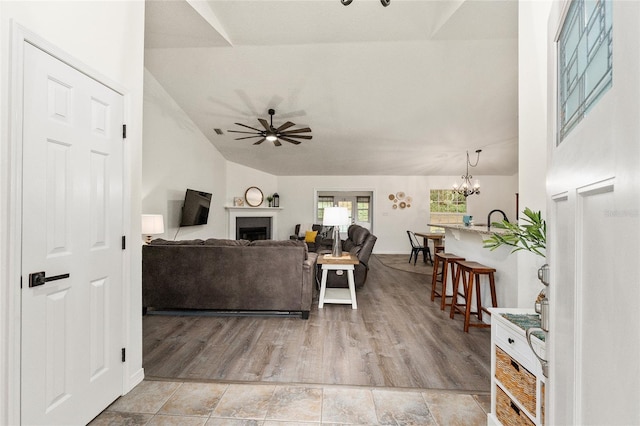 living room with ceiling fan with notable chandelier