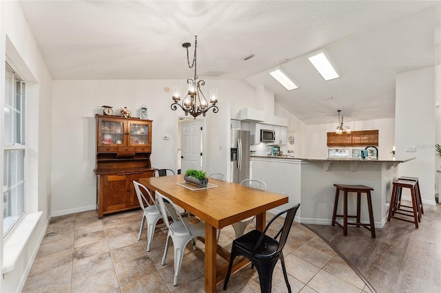 tiled dining space with vaulted ceiling and a notable chandelier