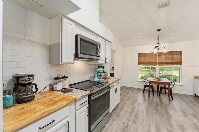 kitchen with tasteful backsplash, stainless steel appliances, an inviting chandelier, white cabinetry, and hanging light fixtures