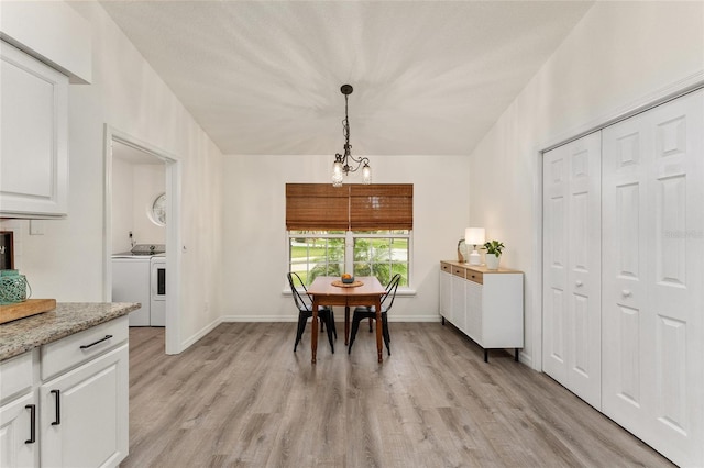 dining area with a chandelier, light hardwood / wood-style floors, and washer and clothes dryer