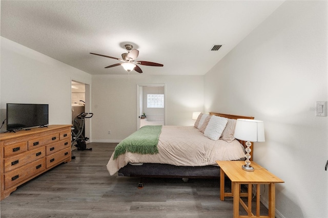 bedroom featuring ceiling fan, dark wood-type flooring, and ensuite bath