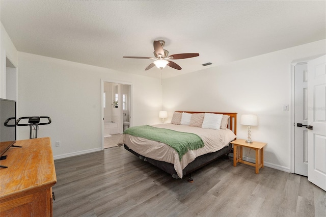 bedroom featuring wood-type flooring, ensuite bath, and ceiling fan