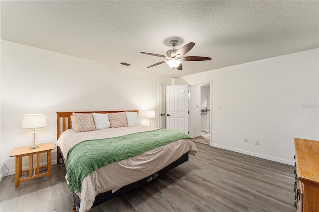 bedroom featuring ceiling fan, dark wood-type flooring, and a textured ceiling