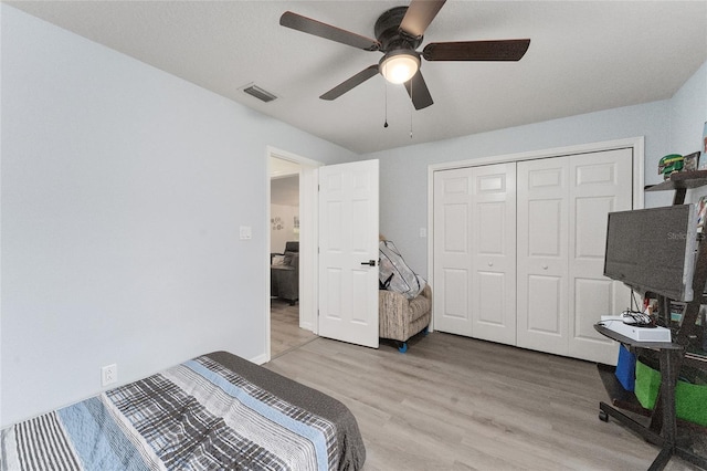 bedroom featuring ceiling fan, light wood-type flooring, and a closet