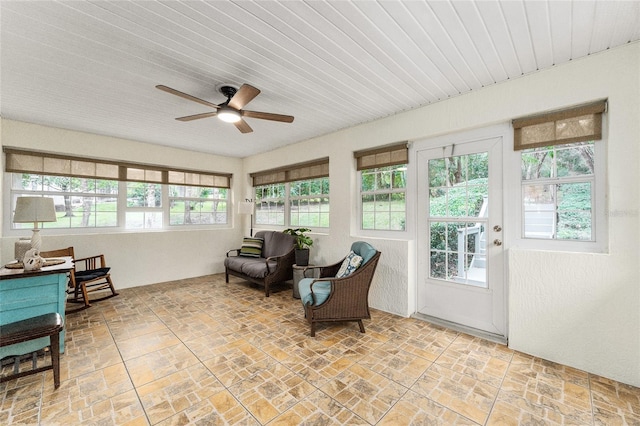 sunroom / solarium with ceiling fan, wooden ceiling, and a wealth of natural light