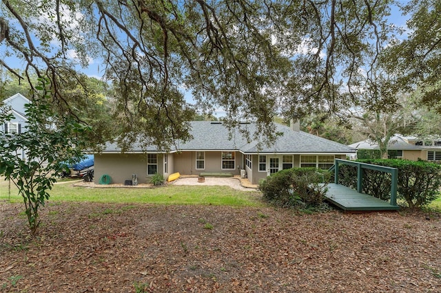 back of house with a deck