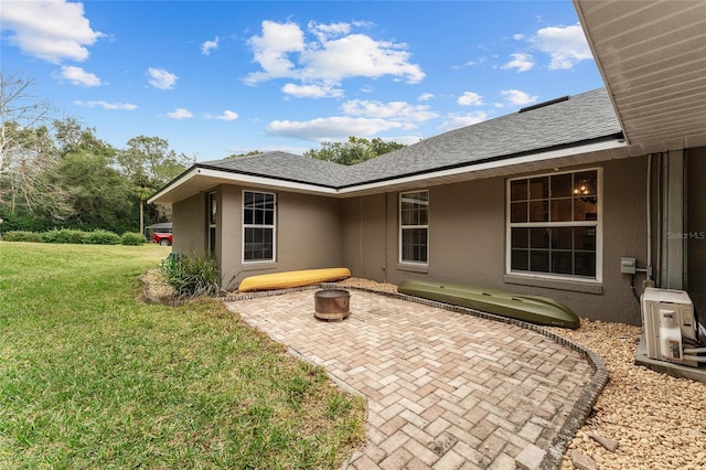 exterior space with ac unit, a yard, and a patio