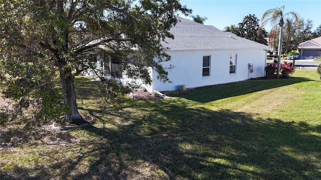 view of side of home with a yard