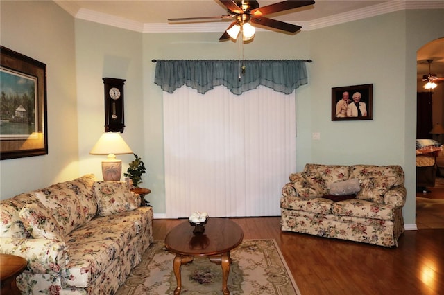 living room featuring dark hardwood / wood-style floors, ceiling fan, and crown molding