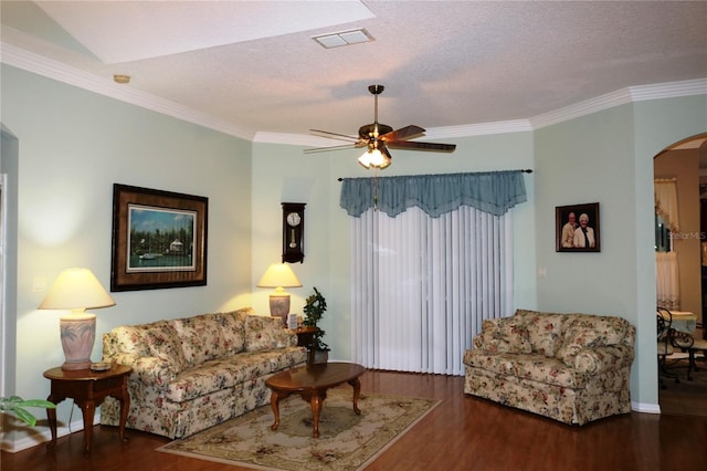 living room featuring ceiling fan, dark hardwood / wood-style floors, ornamental molding, and a textured ceiling