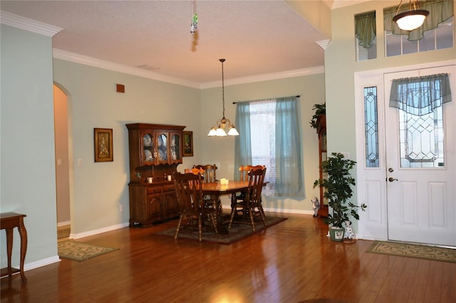 dining area featuring a textured ceiling, an inviting chandelier, dark hardwood / wood-style floors, and ornamental molding