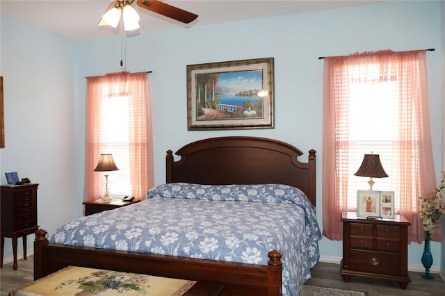 bedroom featuring multiple windows, ceiling fan, and dark hardwood / wood-style flooring