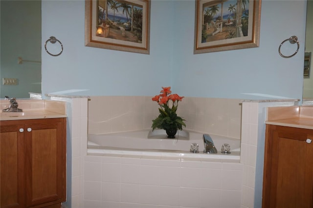 bathroom featuring vanity and tiled tub