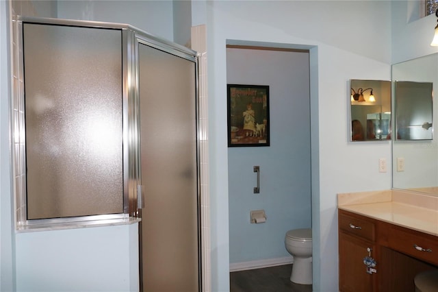 bathroom featuring walk in shower, vanity, wood-type flooring, and toilet