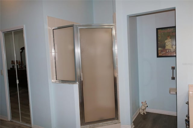 bathroom with an enclosed shower and hardwood / wood-style flooring