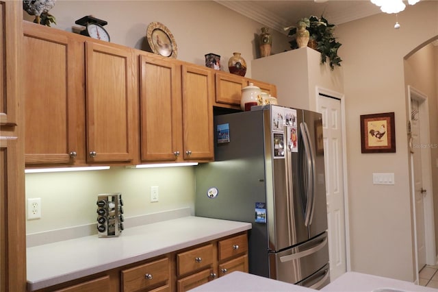 kitchen featuring stainless steel refrigerator and ornamental molding