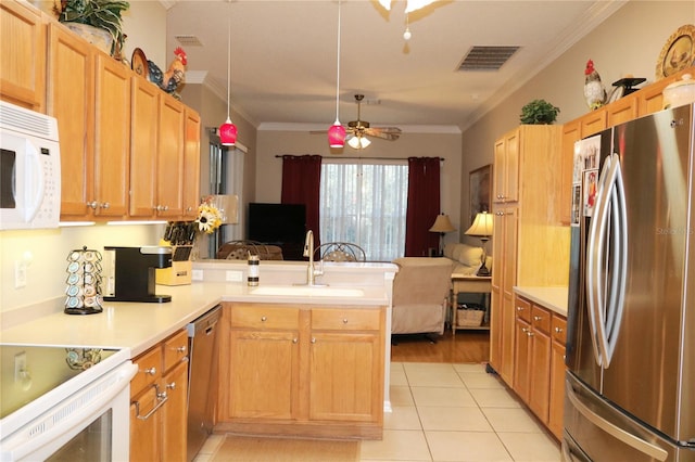 kitchen featuring ceiling fan, sink, kitchen peninsula, appliances with stainless steel finishes, and ornamental molding